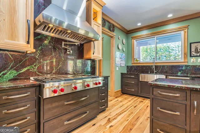 a kitchen with stainless steel appliances granite countertop a stove and a sink