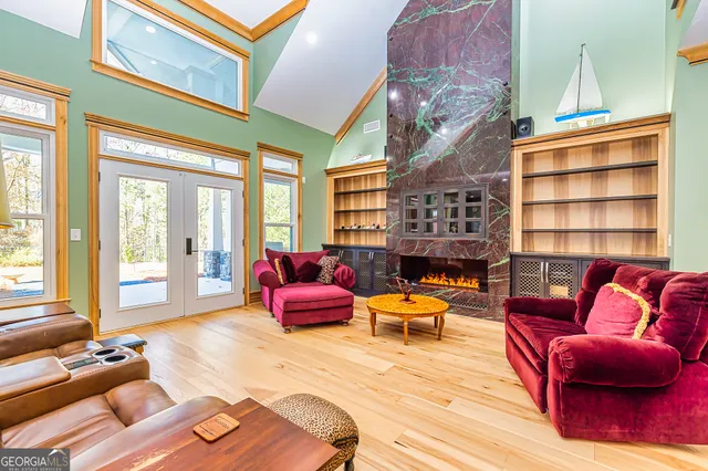 a living room with furniture a rug and a floor to ceiling window