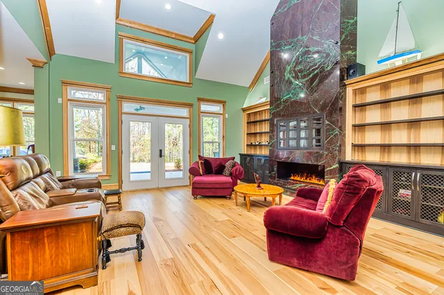 a living room with furniture a fireplace and large windows