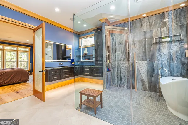 a spacious bathroom with a tub a mirror and a shower