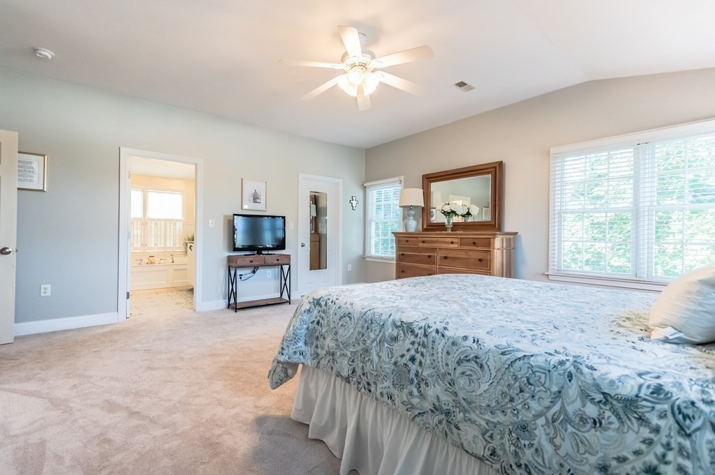 18 Damon Road Scituate, MA 02066 - Photo 16 of 25 a spacious bedroom with a large bed a flat tv screen and a chandelier