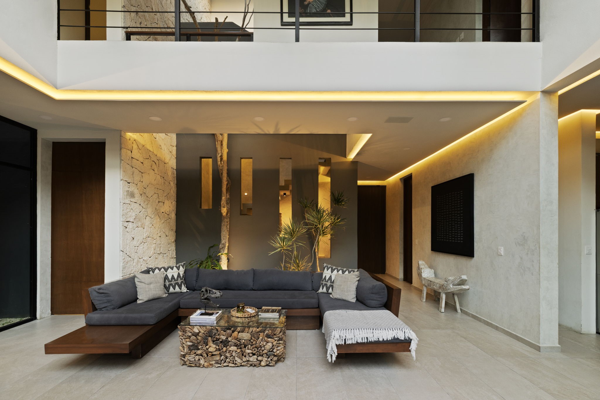 6 Country Club, Unit 4 Nome, TX 77629 - Photo 10 of 45 This spectacular double-height living room features a striking indoor atrium where a living tree grows straight through the heart of the home, embodying the peak of biophilic luxury design.