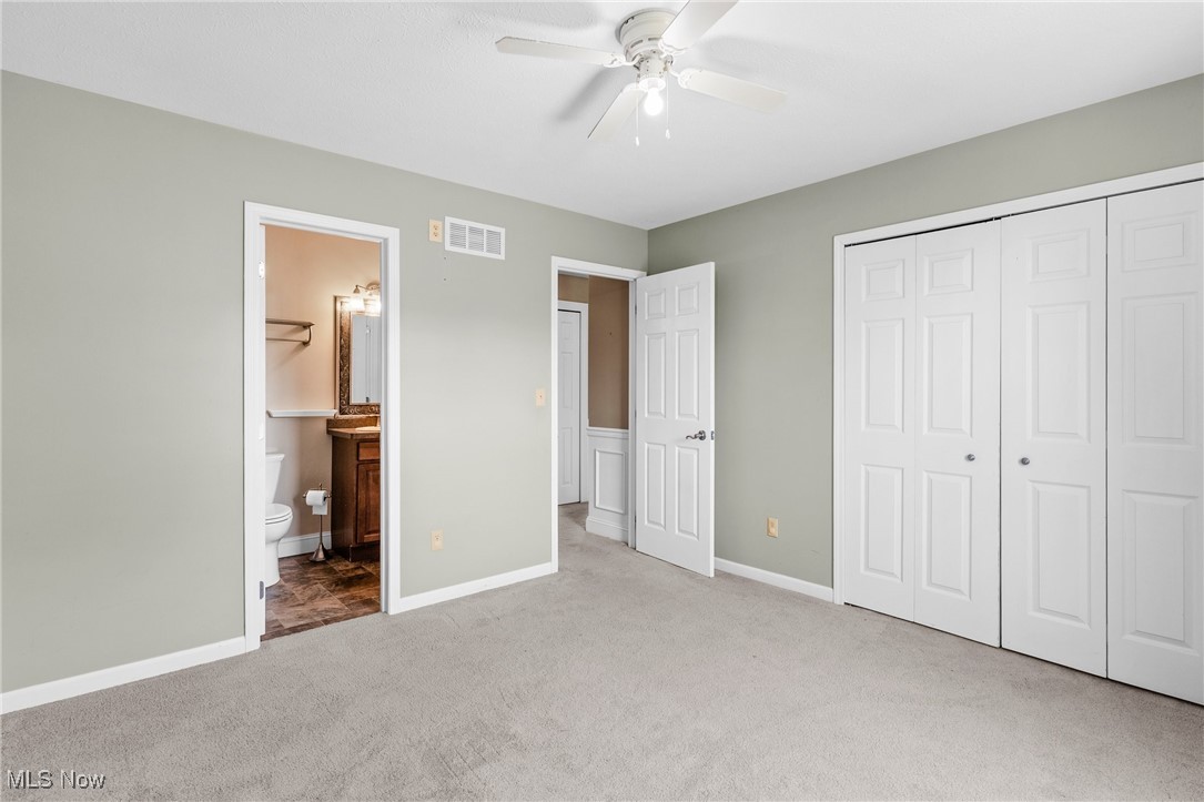 5215 River Road Madison, OH 44057 - Photo 21 of 36 Unfurnished bedroom featuring carpet, a closet, a ceiling fan, and ensuite bathroom