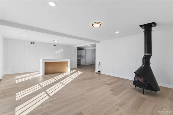 a view of empty room with a fireplace and wooden floor