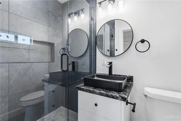 a bathroom with a toilet sink and mirror