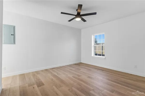 a view of a big room with wooden floor and a window