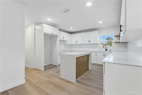 a kitchen with kitchen island white cabinets stainless steel appliances and sink