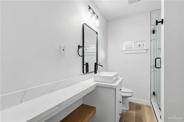 a bathroom with a sink a toilet and shower