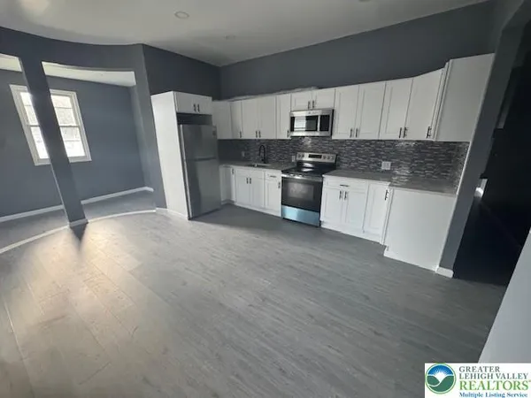 a kitchen with stainless steel appliances a refrigerator sink and microwave