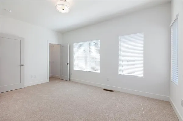 an empty room with windows and closet