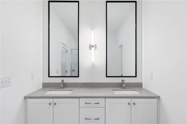 a bathroom with a double vanity sink and a mirror