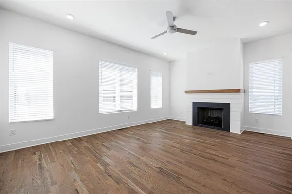 a view of kitchen and empty room with wooden floor