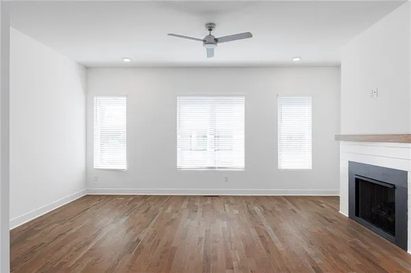 a kitchen with stainless steel appliances granite countertop a stove top oven a sink dishwasher and white cabinets with wooden floor