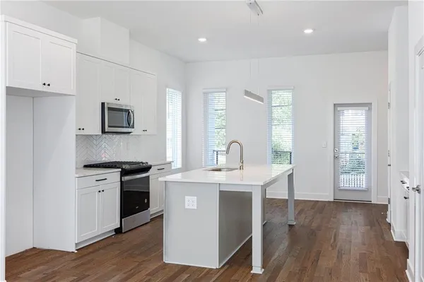 a kitchen with a sink a stove and cabinets