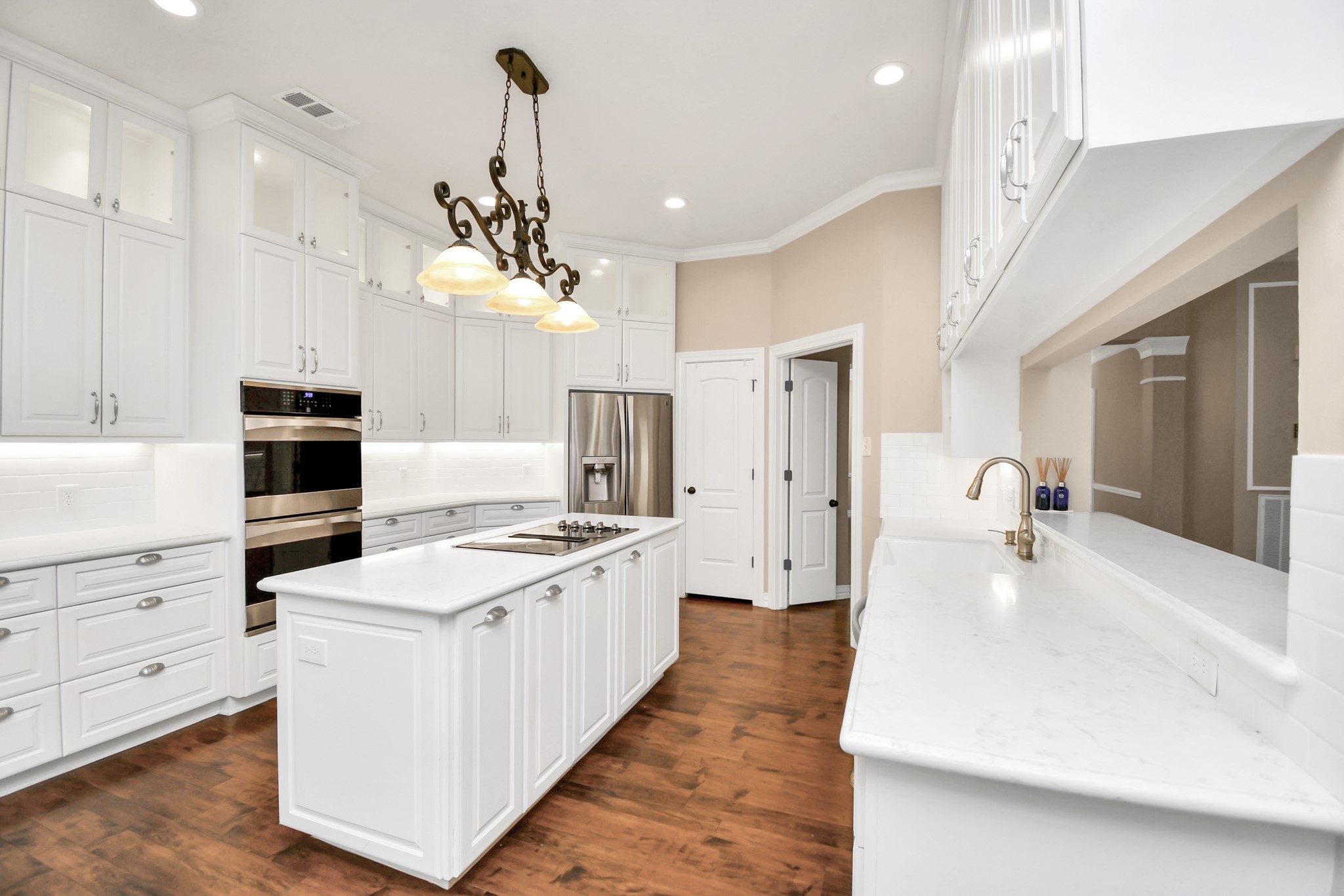 4411 Walham Court Houston, TX 77345 - Photo 18 of 46 a kitchen with kitchen island white cabinets and stainless steel appliances