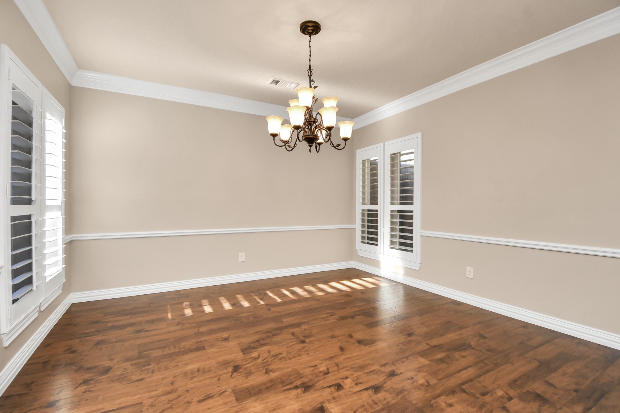 4411 Walham Court Houston, TX 77345 - Photo 7 of 46 an empty room with wooden floor chandelier and windows
