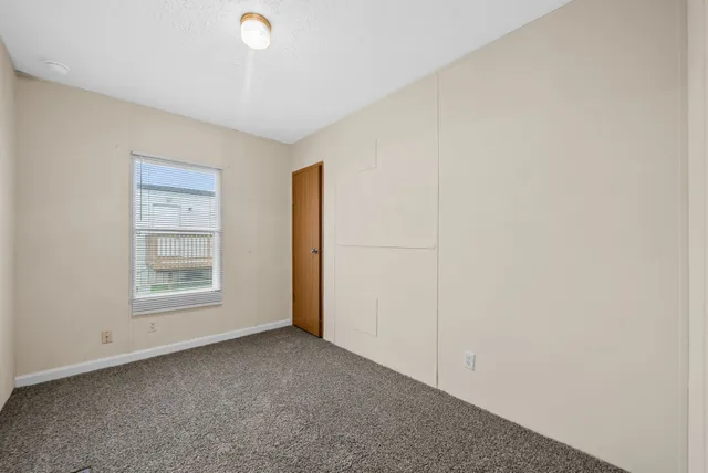 a view of a livingroom with an empty space and a window