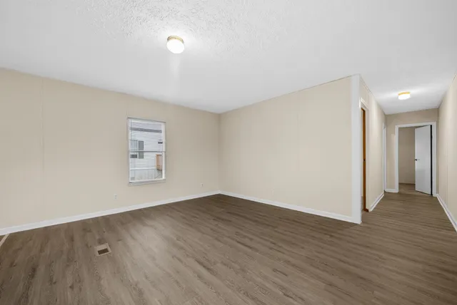 a view of an empty room with wooden floor