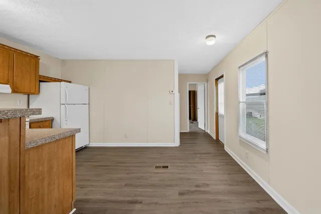 a view of a kitchen with wooden floor and electronic appliances