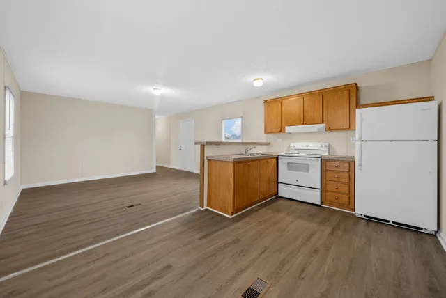 a kitchen with wooden floors and white cabinets
