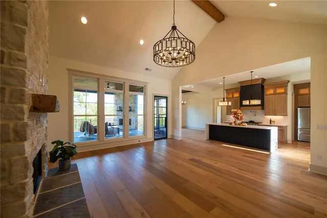 an empty room with wooden floor and a ceiling fan