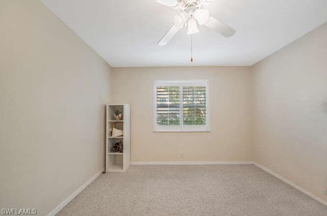 778 Broad Court South Naples, FL 34102 - Photo 17 of 36 an empty room with chandelier fan and windows