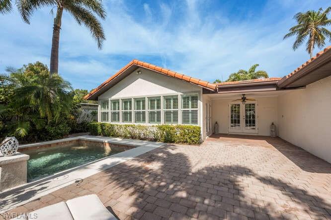 778 Broad Court South Naples, FL 34102 - Photo 33 of 36 a front view of a house with a garden and patio