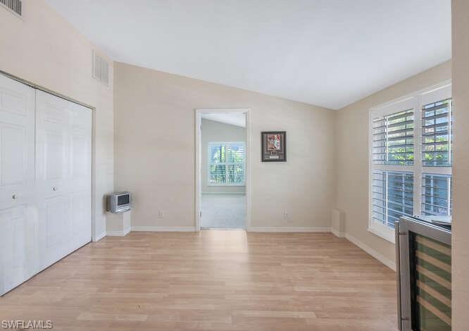 778 Broad Court South Naples, FL 34102 - Photo 8 of 36 a view of an empty room with wooden floor and a window