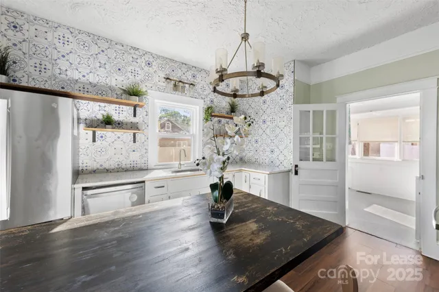 a living room with stainless steel appliances granite countertop furniture and wooden floor