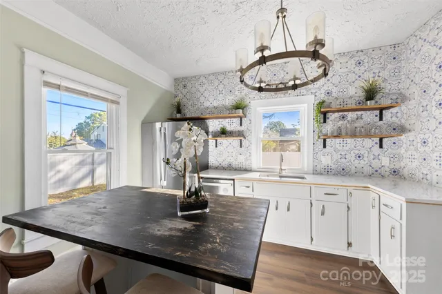 a kitchen with a table chairs and white cabinets
