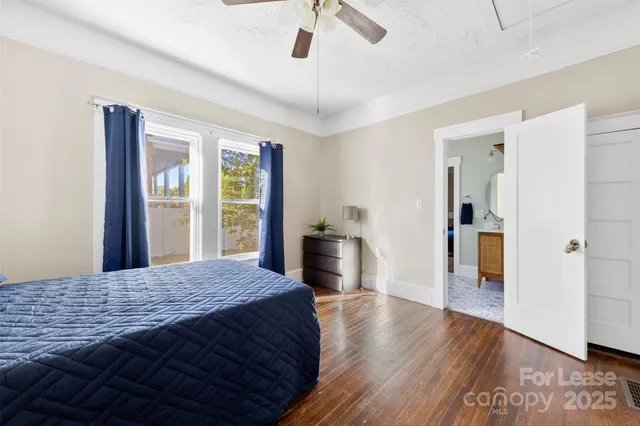 a bedroom with a balcony and wooden floor