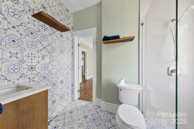 a white toilet sitting next to a bathroom sink