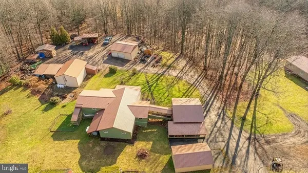 an aerial view of a house with swimming pool and outdoor seating