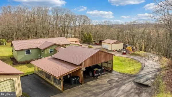 a aerial view of a house with swimming pool and large trees