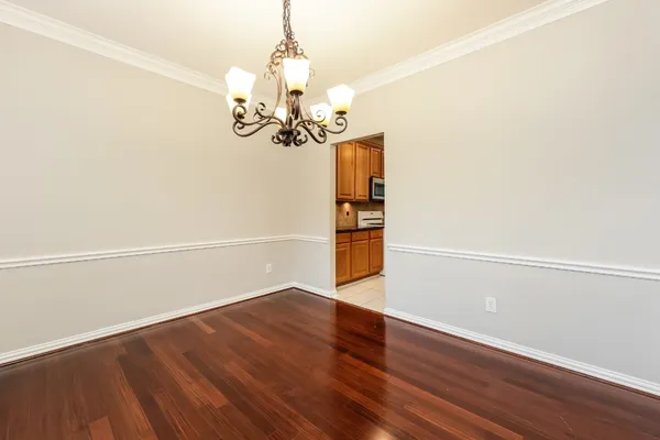 a kitchen with stainless steel appliances granite countertop a refrigerator a sink dishwasher a stove and white countertops with wooden floor