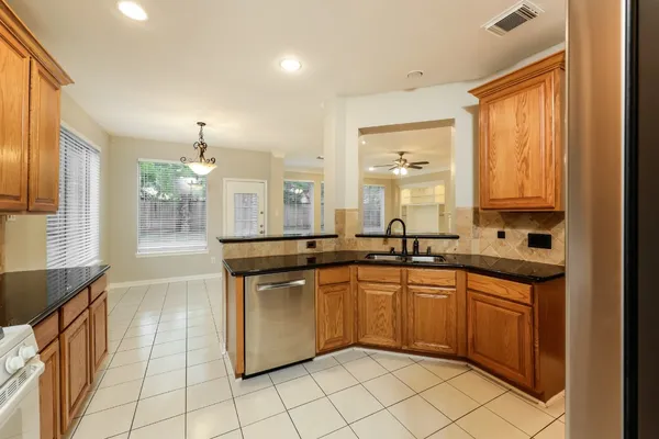 an empty room with wooden floor ceiling fan and windows