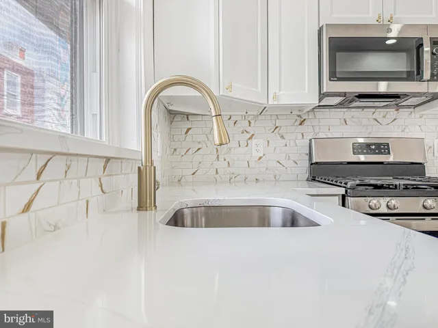 a kitchen with stainless steel appliances a stove a microwave and a sink