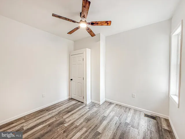 a view of a livingroom with wooden floor and a ceiling fan