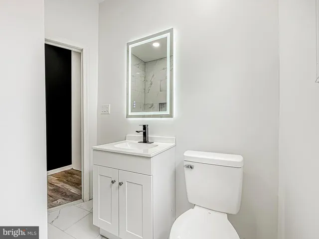 a bathroom with a toilet sink and mirror