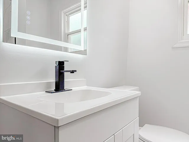 a bathroom with a sink a toilet and window