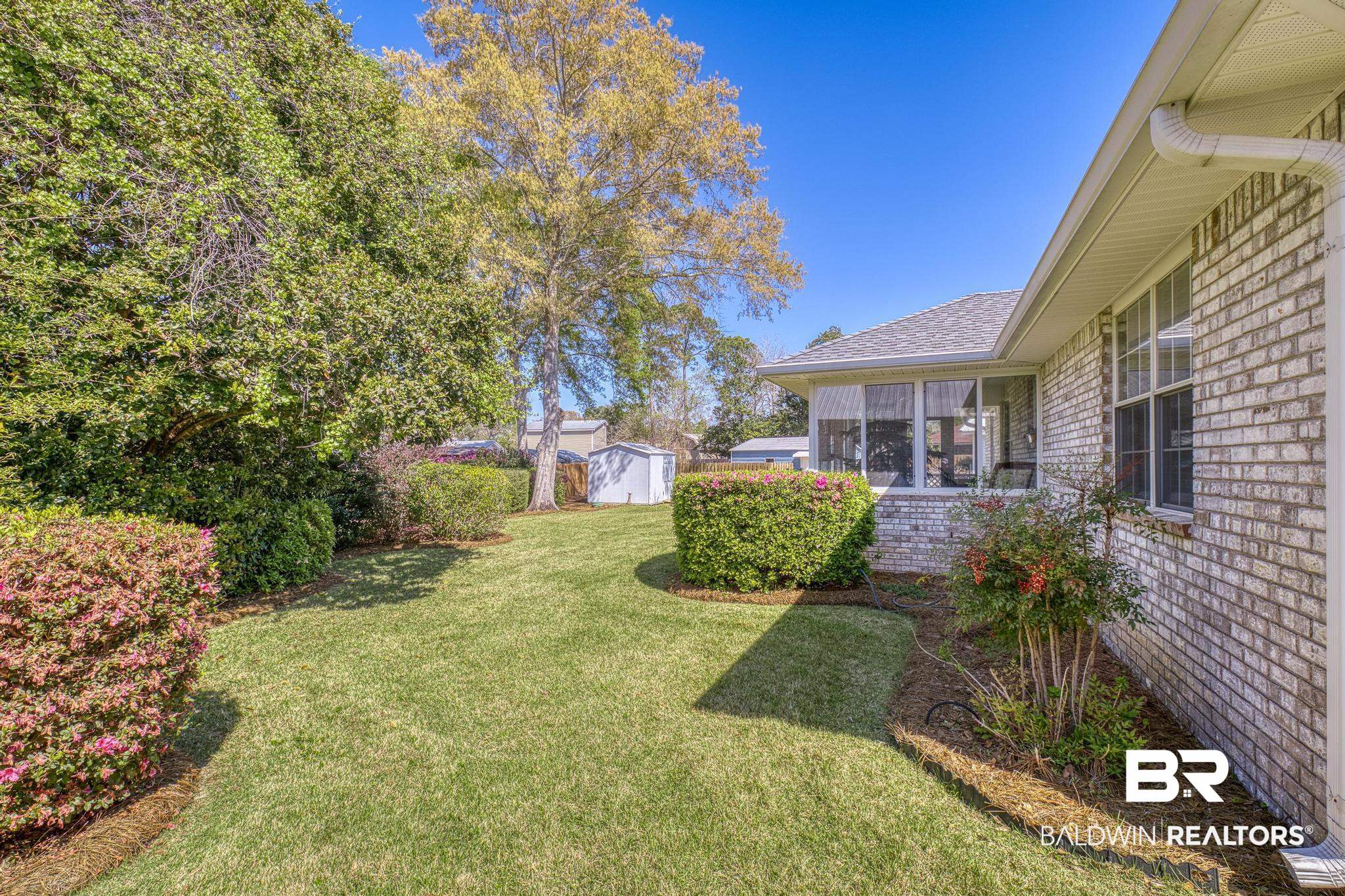 2881 Eslava Circle Lillian, AL 36549 - Photo 28 of 58 View of grassy yard with a sunroom and a storage shed