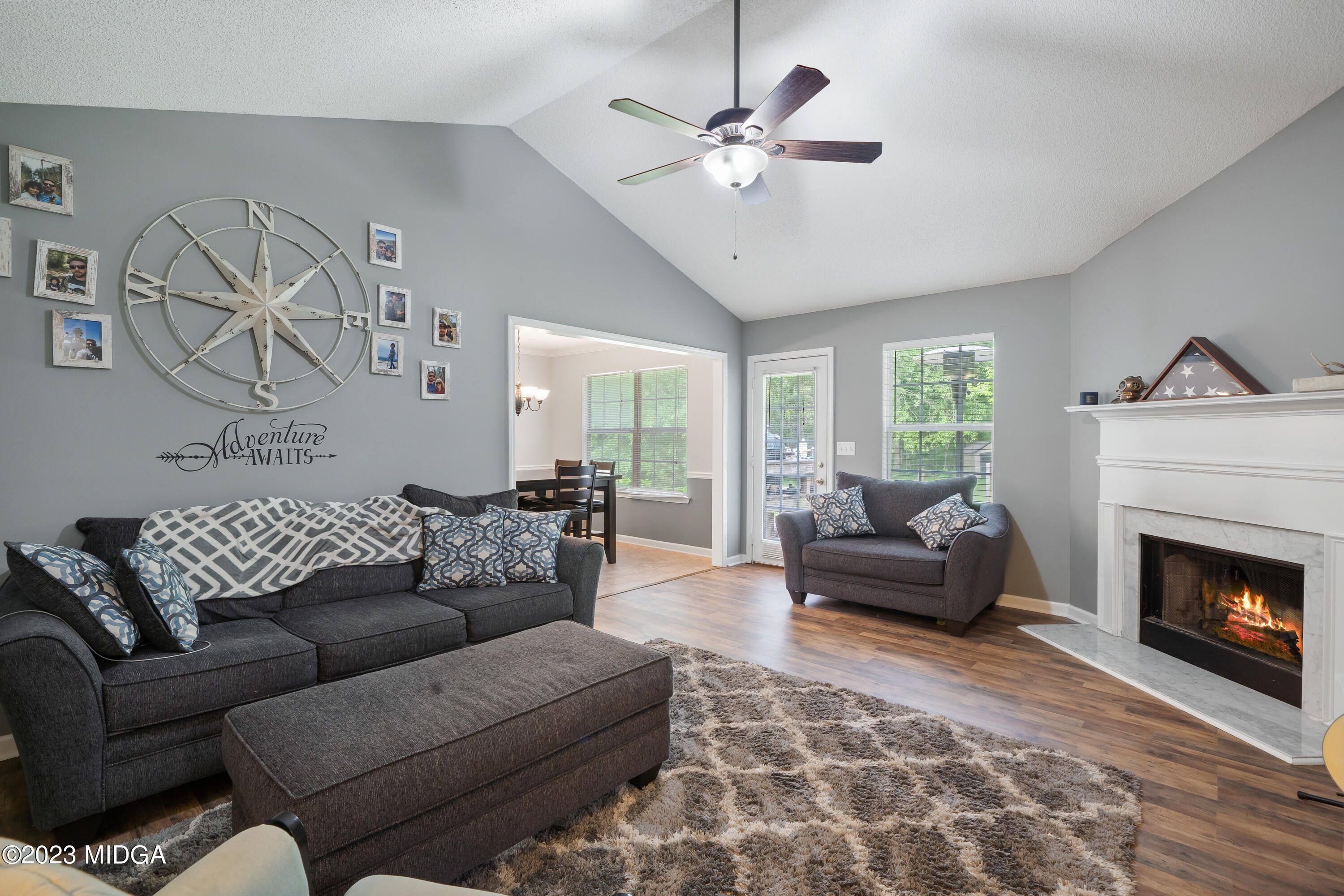 259 Autumn Ridge Court Gray, GA 31032 - Photo 6 of 18 a living room with furniture a fireplace and a chandelier