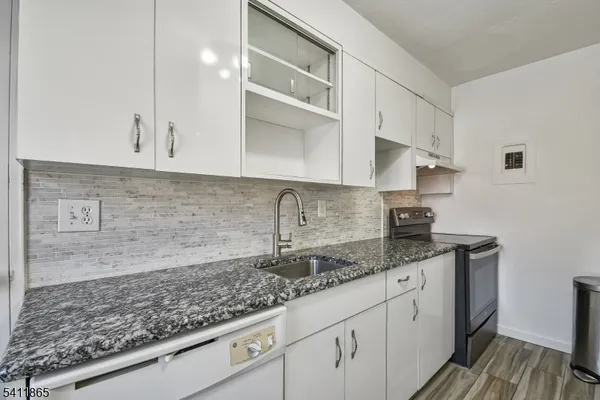 a kitchen with granite countertop a sink and cabinets