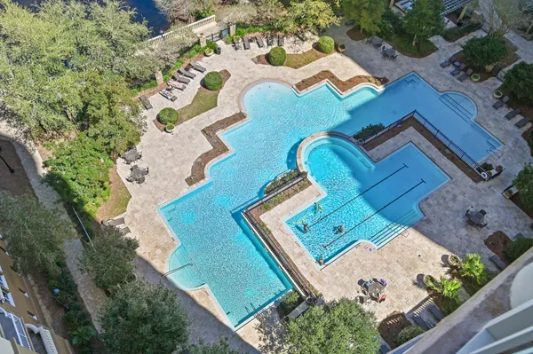 a view of a swimming pool with a patio and a backyard