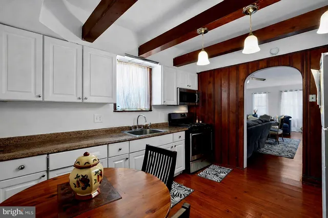 a kitchen with a sink cabinets and wooden floor