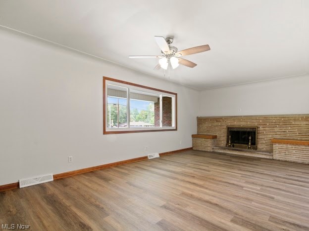 717 Struthers-Liberty Road Campbell, OH 44405 - Photo 6 of 14 Unfurnished living room with hardwood flooring, ceiling fan, and a fireplace