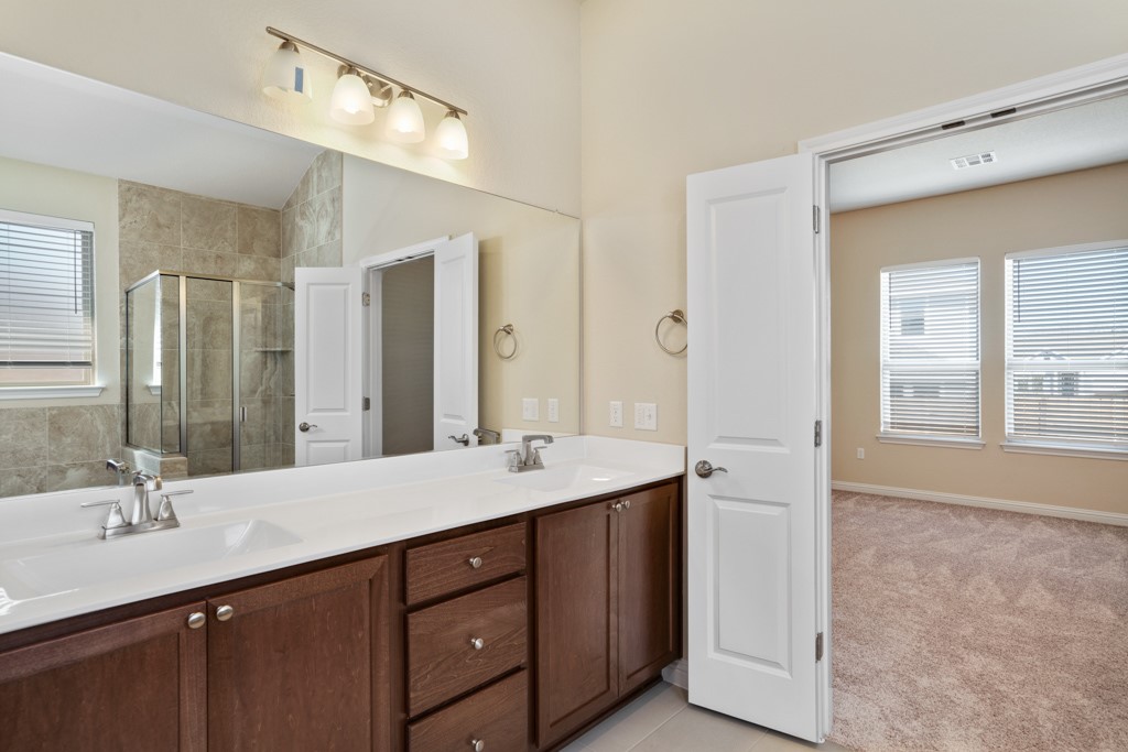 8202 Dampton Lane Austin, TX 78744 - Photo 15 of 25 a bathroom with a sink double vanity and a mirror