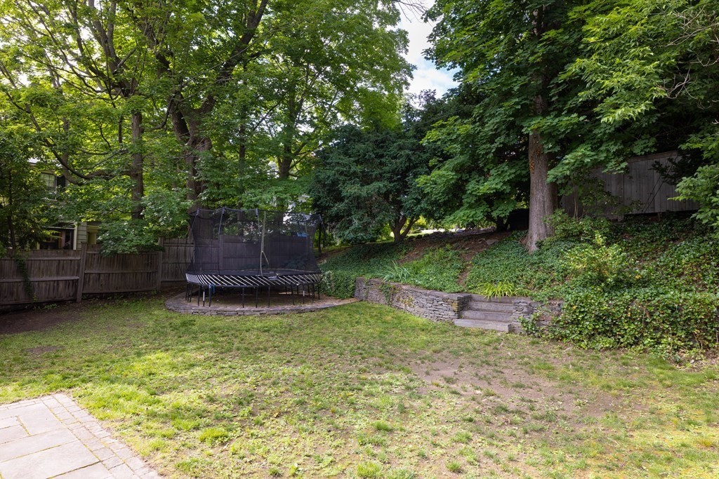 43 Somerset Road Brookline, MA 02445 - Photo 18 of 18 a view of a backyard with large trees and wooden fence