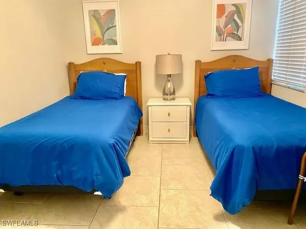 a bedroom with a bed and two windows