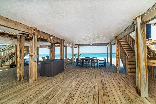 a view of a balcony with chairs and wooden floor